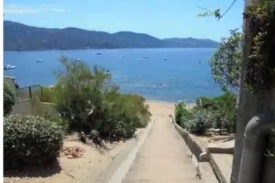 a path leading to a beach with a body of water at F2 pieds dans l'eau in Casaglione