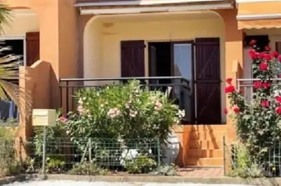 a house with flowers on the front porch at F2 pieds dans l'eau in Casaglione