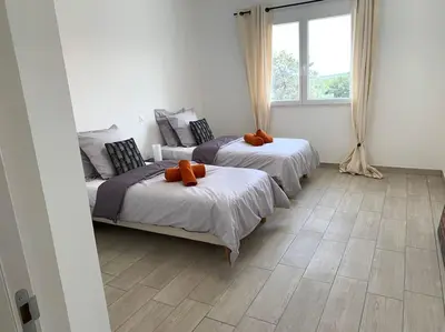 a bedroom with two beds and a window at L'alivu di porto vecchio*** ( piscine chauffée ) in Porto-Vecchio