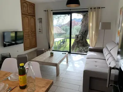 a living room with a couch and a table at L'alivu di porto vecchio*** ( piscine chauffée ) in Porto-Vecchio