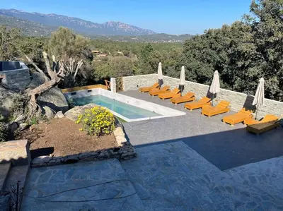 a swimming pool with lounge chairs and umbrellas at L'alivu di porto vecchio*** ( piscine chauffée ) in Porto-Vecchio