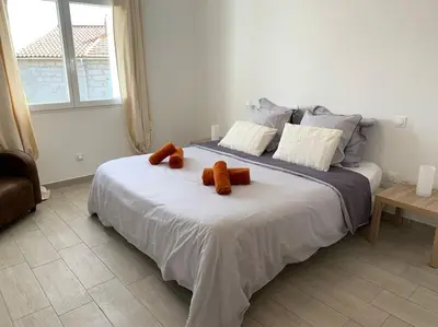 a large white bed with two orange pillows on it at L'alivu di porto vecchio*** ( piscine chauffée ) in Porto-Vecchio