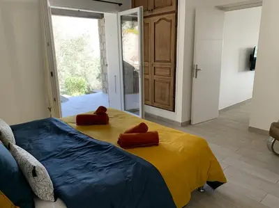 a bedroom with a bed with two red pillows on it at Caminu di porto vecchio***. (Piscine chauffée ) in Porto-Vecchio