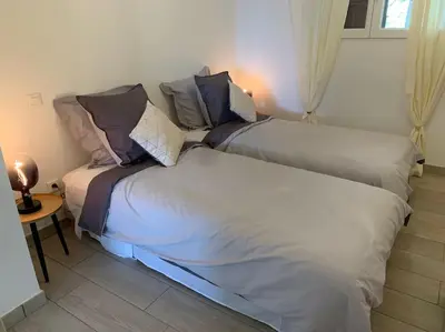 two beds sitting next to each other in a room at Caminu di porto vecchio***. (Piscine chauffée ) in Porto-Vecchio