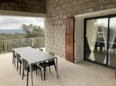 a patio with a table and chairs on a balcony at Caminu di porto vecchio***. (Piscine chauffée ) in Porto-Vecchio