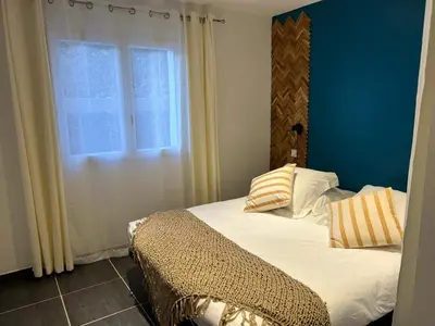 a bed with two pillows on it in front of a window at Umbria di Porto Vecchio*** in Porto-Vecchio