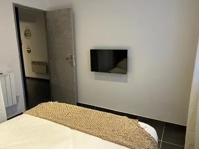 a bedroom with a bed and a tv on a wall at Umbria di Porto Vecchio*** in Porto-Vecchio