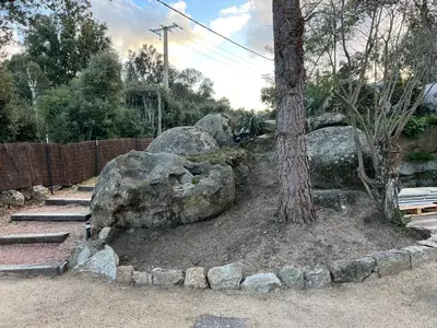 a rock garden with a tree and a fence at Umbria di Porto Vecchio*** in Porto-Vecchio