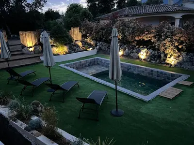 a backyard with a pool with chairs and umbrellas at Umbria di Porto Vecchio*** in Porto-Vecchio
