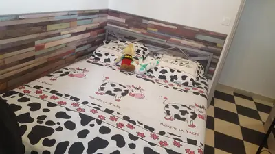 a bed with a cow crib with a toy on it at maison T3 500m de la plage in Poggio-Mezzana