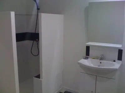 a white bathroom with a sink and a shower at maison T3 500m de la plage in Poggio-Mezzana