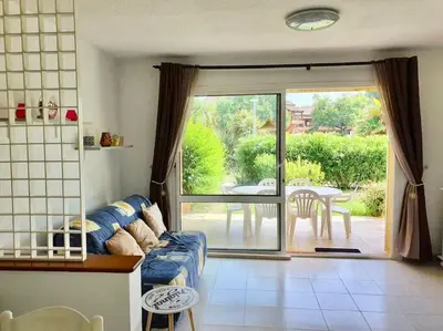 a living room with a couch and a sliding glass door at Charmant bonheur en bord de mer in Ghisonaccia