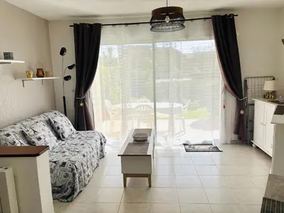 a living room with a couch and a large window at Charmant bonheur en bord de mer in Ghisonaccia
