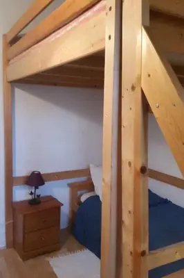 a wooden bunk bed with a lamp on a table at Gîte E Curtaline in Speloncato