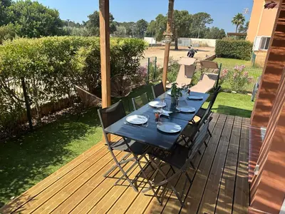 a black table with chairs on a wooden deck at Mini Villa 4-6 pers. Les hameaux de Saint Cyprien in Lecci