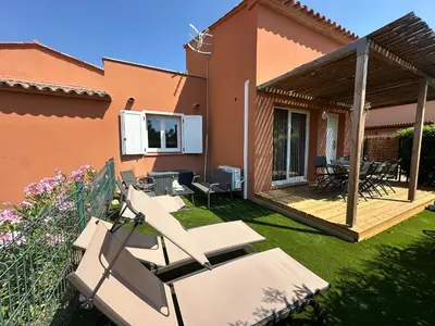 a yard with chairs and a deck with a house at Mini Villa 4-6 pers. Les hameaux de Saint Cyprien in Lecci