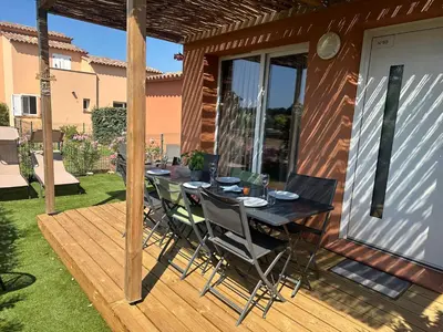 a wooden deck with a table and chairs on it at Mini Villa 4-6 pers. Les hameaux de Saint Cyprien in Lecci