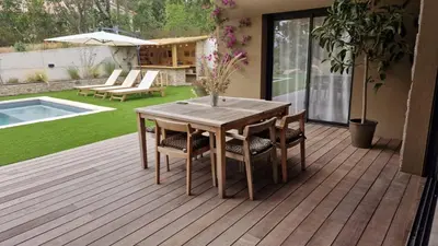 a wooden deck with a wooden table and chairs at VILLA AVEC PISCINE PORTO-VECCHIO CORSICA in Porto-Vecchio