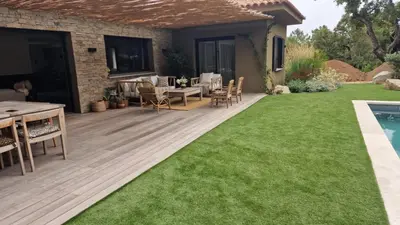 a backyard with a wooden deck and grass at VILLA AVEC PISCINE PORTO-VECCHIO CORSICA in Porto-Vecchio