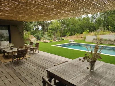 a patio with a table and chairs and a swimming pool at VILLA AVEC PISCINE PORTO-VECCHIO CORSICA in Porto-Vecchio