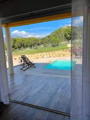 a balcony with a view of a swimming pool at Très belle villa au calme avec piscine à Sagone in Sagone