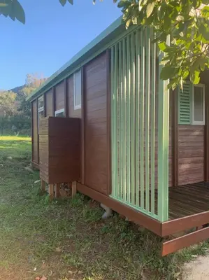 a building with wooden panels on the side of it at Chalet au calme à Sagone en Corse in Sagone