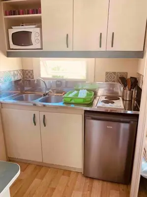 a small kitchen with a sink and a dishwasher at Chalet au calme à Sagone en Corse in Sagone