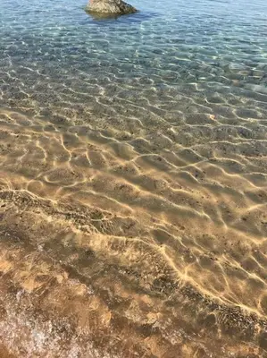 a close up of the sand in the water at Chalet au calme à Sagone en Corse in Sagone
