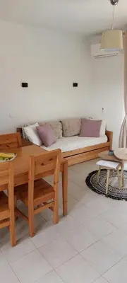 a living room with a couch and a table at Location appartement les pieds dans l'eau, Résidence Aqua Linda à Poggio-Mezzana in Poggio-Mezzana