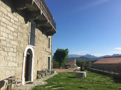 a building with a grass yard next to a building at A Casa Carbinesa in Carbini