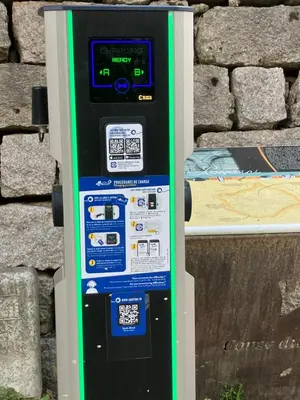 a green and black parking meter next to a wall at A Casa Carbinesa in Carbini