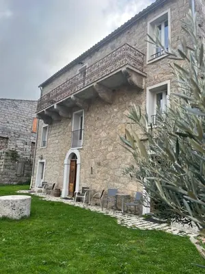 a stone building with chairs in a yard at A Casa Carbinesa in Carbini