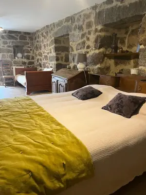 a bedroom with a large bed in a room with stone walls at A Casa Carbinesa in Carbini