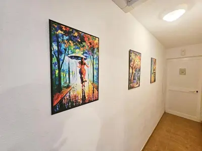 a painting of a woman with an umbrella on a wall at Casa Johanna, plage et piscine in Moriani Plage