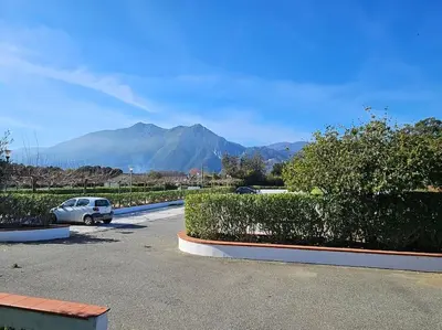 a car parked in a parking lot with mountains in the background at Casa Johanna, plage et piscine in Moriani Plage