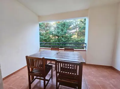 a table and chairs on a balcony with a large window at Casa Johanna, plage et piscine in Moriani Plage