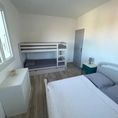 a white bedroom with a bed and a couch at Appartement entre mer et montagne avec beau jardin in Calenzana