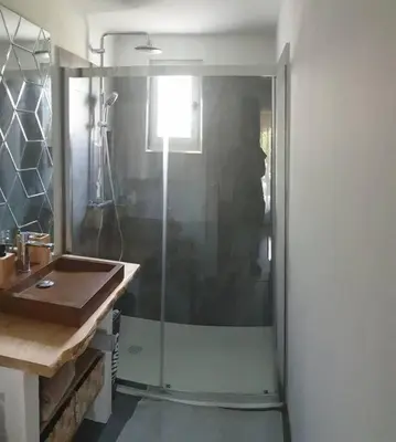 a bathroom with a glass shower and a sink at Villa les pieds dans l'eau résidence calme in Poggio-Mezzana