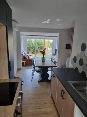 a kitchen with a table in the middle of a room at Villa les pieds dans l'eau résidence calme in Poggio-Mezzana