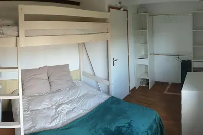 a bedroom with a bunk bed with a ladder at Villa les pieds dans l'eau résidence calme in Poggio-Mezzana