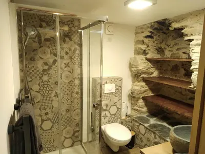 a bathroom with a toilet and a glass shower at U MULINU in Moïta