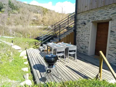 a grill on a wooden deck next to a building at U MULINU in Moïta