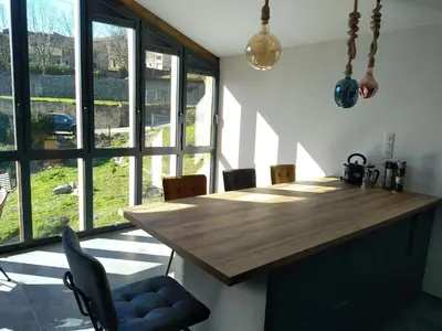 a kitchen with a wooden table and some windows at U MULINU in Moïta