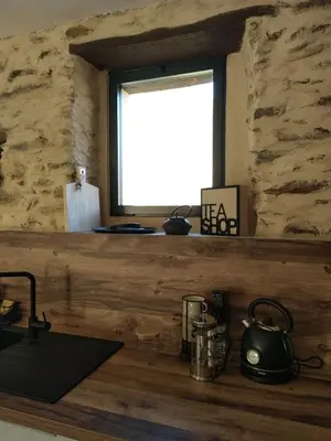 a kitchen with a counter with a window and a sink at U MULINU in Moïta
