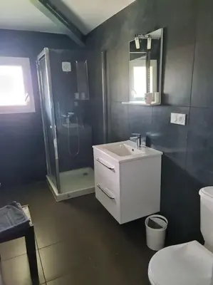 a bathroom with a sink and a shower and a toilet at Appartement de détente et vue sur montagnes in Ghisonaccia