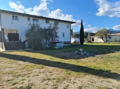 a large white house with a large yard at Appartement de détente et vue sur montagnes in Ghisonaccia