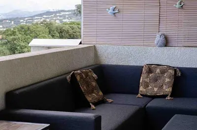 a blue couch with two pillows on a balcony at Casamea - Vue mer, Terrasse, Clim, Proche Plage in Porticcio