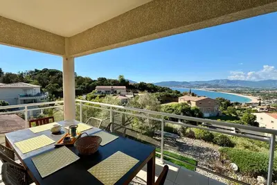 a dining table on a balcony with a view of the ocean at Casamea - Vue mer, Terrasse, Clim, Proche Plage in Porticcio