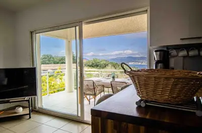 a kitchen with a large glass door leading to a patio at Casamea - Vue mer, Terrasse, Clim, Proche Plage in Porticcio