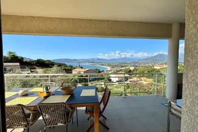 a table and chairs on a balcony with a view at Casamea - Vue mer, Terrasse, Clim, Proche Plage in Porticcio